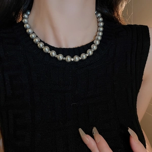 Close-up of elegant silver-gray pearl choker necklace worn on model for a classic look