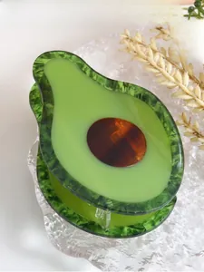 Close-up of creative avocado acetate hair claw with green marble texture and brown core
