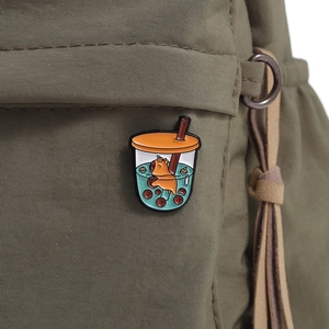 Close-up of a cute capybara in a bubble tea cup enamel pin on a green canvas bag