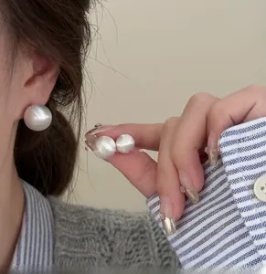 Detailed macro view of large brushed white pearl earrings in 14mm and 16mm sizes