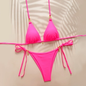 Detail of neon pink bikini with golden starfish pendants and side-tie metal rings