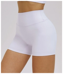 Detail of high-waisted white yoga shorts showing vertical ribbed texture and elastic fabric