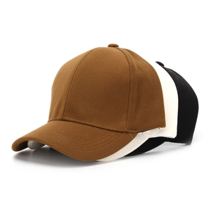 Close-up showing textured knit fabric detail of stacked brown, white, and black baseball caps
