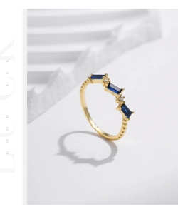 Detail view of gold vintage ring with baguette-cut blue gemstones and white diamonds