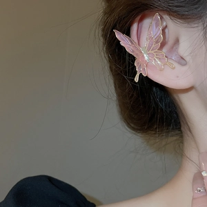 Detail view of pink butterfly ear cuff with golden edges and shimmering resin wing
