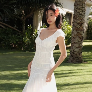 Détail de la robe blanche à col en V avec taille plissée et détails de cordon serrage