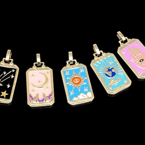 Detail of five colorful tarot card pendants in gold plating with vibrant enamel finish
