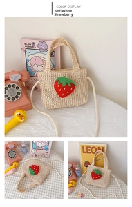Detail of cream straw strawberry bag for kids showing woven texture and plush fruit patch