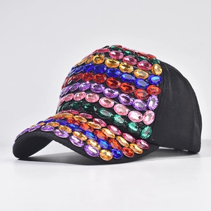 Dettaglio di strass colorati e cristalli scintillanti su un cappellino da baseball nero