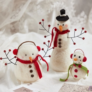 Three sizes of handcrafted white wool felt snowmen with festive red and green scarves