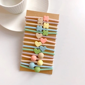 Detail of high-elasticity macaron hair ties with heart and flower charms on card