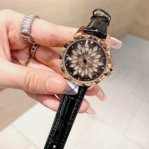 Close-up of a women's fashion watch with rotating crystal flower dial and black leather strap