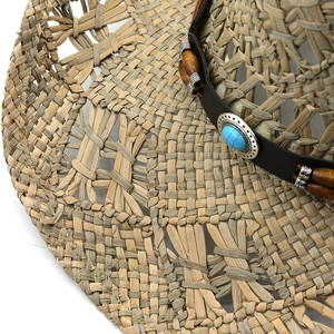 Vue détaillée d'un chapeau de paille avec bande en cuir, perles en bois et turquoise