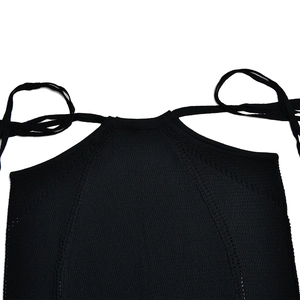 Dettaglio del top a lupetto nero in maglia con trama traforata su scollo e spalle