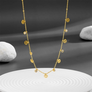 Elegant gold evil eye necklace with multiple clear zircon charms on a display tray