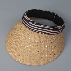 Macro view of woven straw sun hat with silver rhinestones and zebra print headband