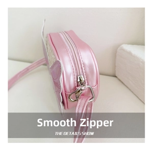 Detail shot of smooth silver zipper and metal buckle on pink butterfly shoulder bag