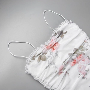 Makro-Detail von Blumenprint-Mesh-Stoff mit feinem weißen Spitzenbesatz am Sommerkleid