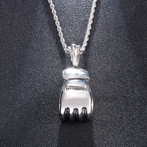 Detailed close-up of a silver boxing glove pendant with twisted chain on black background
