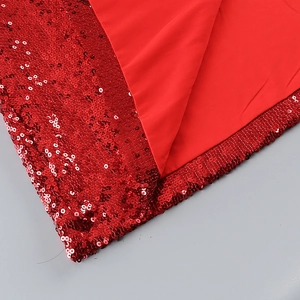 Close-up of sparkling red sequins fabric and soft polyester lining of a skirt