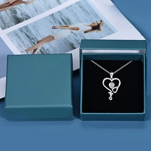 Vista detallada del collar estetoscopio de plata en una caja de regalo de terciopelo verde