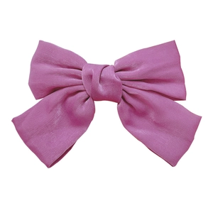 Elegant purple satin bow hair accessory with glossy fabric for a chic, feminine look