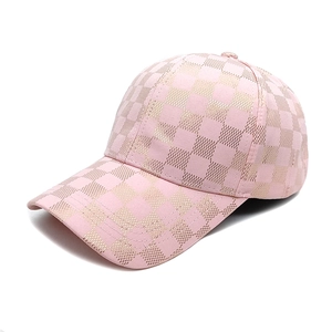 Detail of pink baseball cap featuring elegant gold plaid pattern and metallic finish