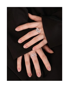 Close-up of S925 silver rings with hollow heart and knot design worn on hand
