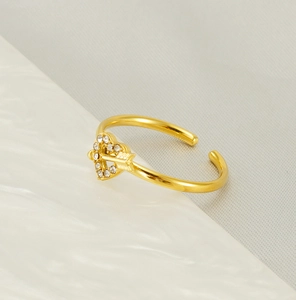 Macro shot of 18k gold heart and arrow adjustable ring with white zircon stones