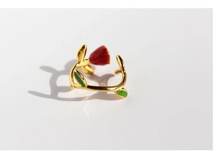 Detail view of handmade red enamel rose ring with green leaves on golden adjustable band