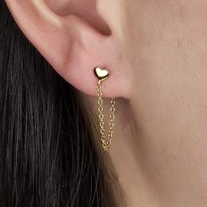 Macro view of a golden heart stud earring featuring a delicate chain tassel design