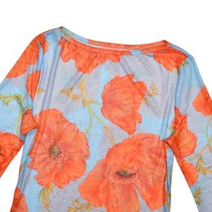 Close-up of sheer blue mesh fabric featuring vibrant orange poppy flower prints