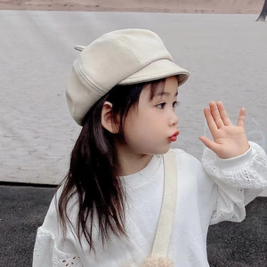 Detail of a beige kid's newsboy cap made of wool fabric for a stylish autumn look