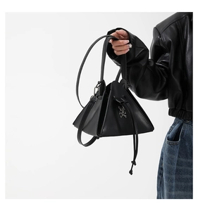 Detailed view of punk style triangle handbag with skull metal badge and drawstring closure