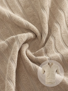 Vue macro détaillée du tissu éponge tricoté beige avec texture 3D sur un polo pour hommes