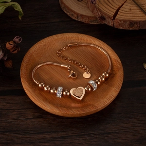 Détail macro du pendentif cœur dépoli sur bracelet chaîne serpent en or rose poli