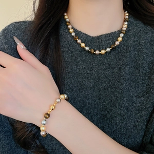 Détail de l'ensemble collier et bracelet magnétique en œil de tigre et perles rétro