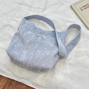 Détail du sac à bandoulière en velours côtelé bleu clair avec motifs de cœurs blancs