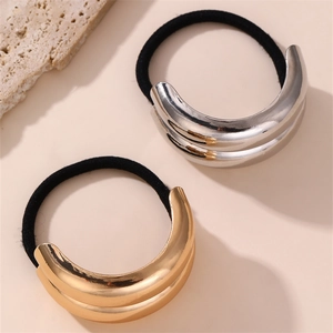 Detail of minimalist metallic cross hair ties in polished gold and silver finishes