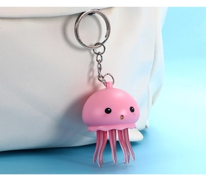 Porte-clés méduse rose lumineux suspendu à un sac à main en tissu blanc pur