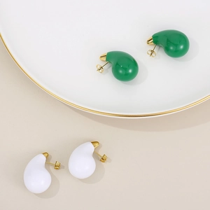 Detailed shot of green and white teardrop stud earrings with gold plating and studs