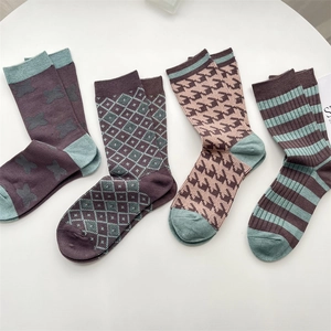 Close-up of four pairs of retro plaid and houndstooth pattern cashmere socks in purple