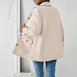 Detail of off-white wool coat featuring side view of large pockets and metallic buttons