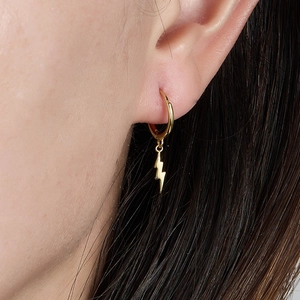 Close-up of gold lightning bolt hoop earrings featuring pavé cubic zirconia inlay on model