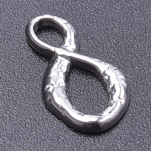 Macro detail of 304 stainless steel infinity symbol pendant with hammered texture and ring