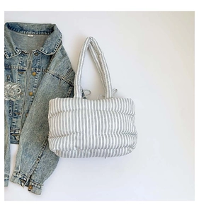 Détail du sac fourre-tout matelassé à rayures bleu et blanc avec poignées cylindriques
