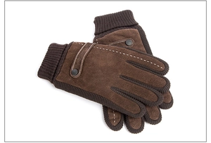 Detail view of brown pigskin leather gloves with knitted cuffs and decorative strap buttons