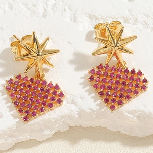 Detail of golden star studs with magenta zircon heart pendants on white stone