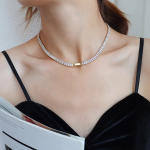 Elegant gold titanium necklace with baguette-cut pavé zircons worn on a model's neck