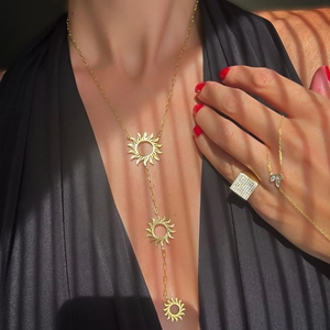 Golden stainless steel sunflower necklace with three tiered pendants on a model